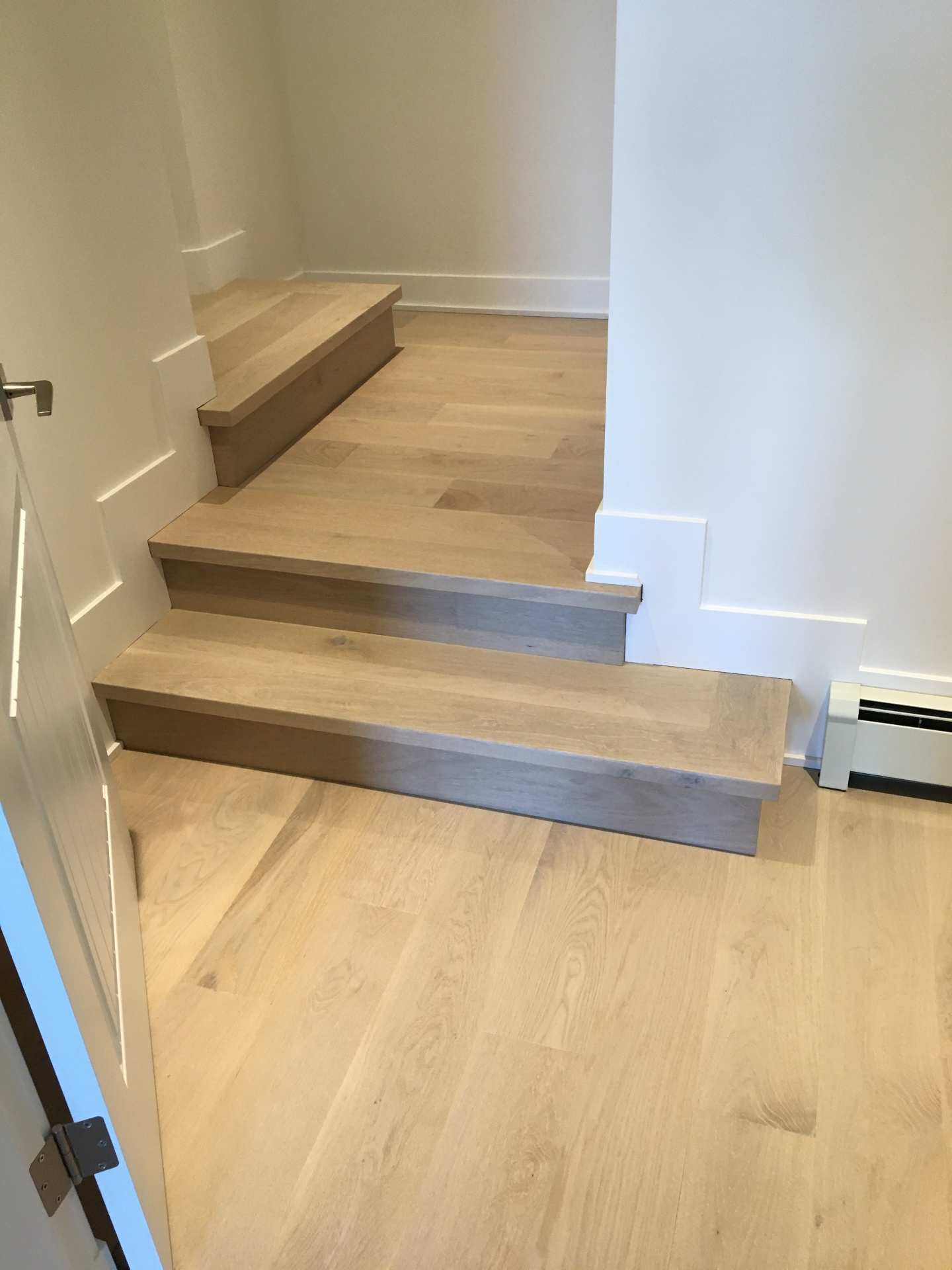 Point Grey Rd Vancouver Home — white oak step transition between hallway and lower hardwood floor