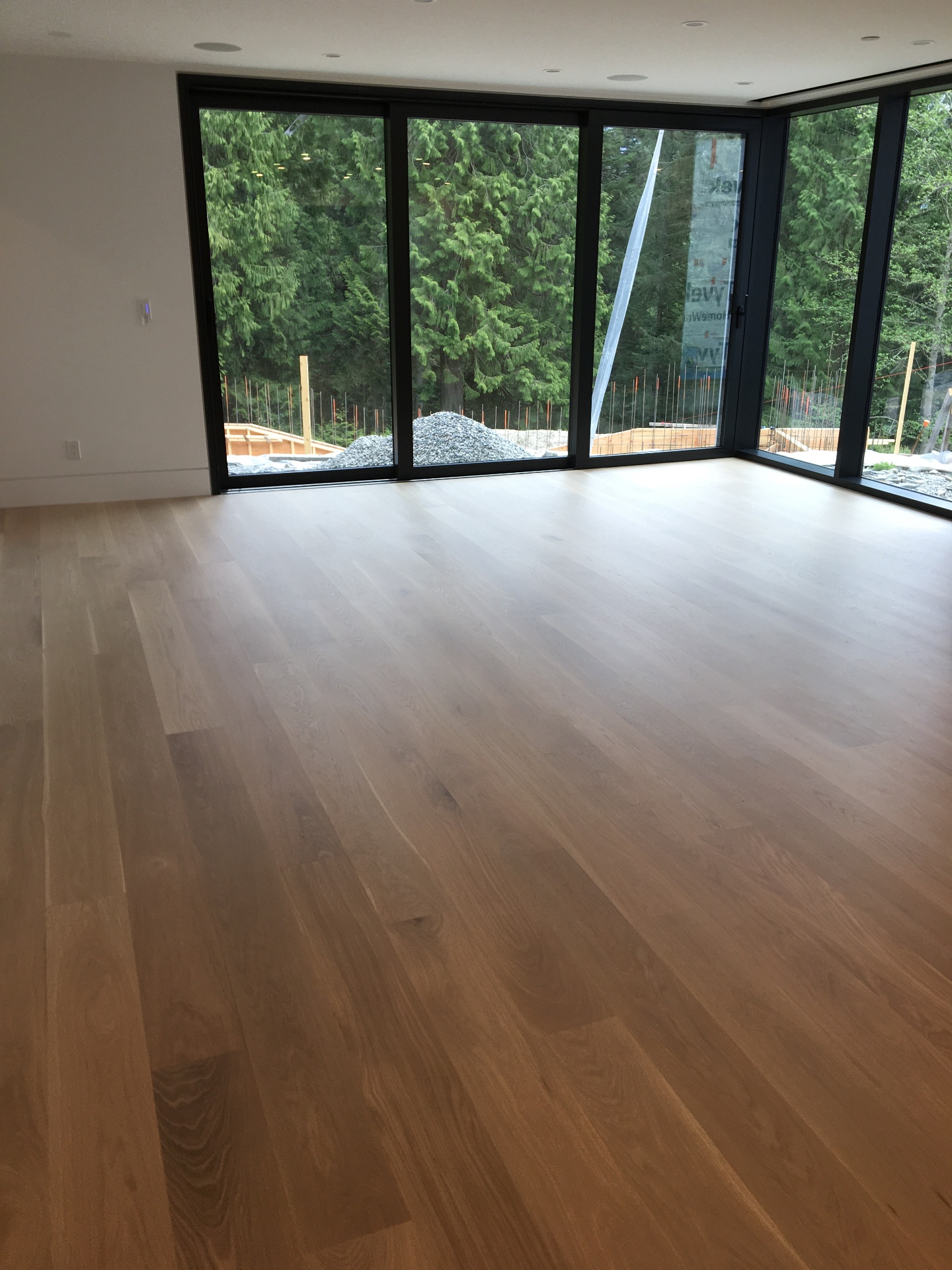 West Vancouver Home — wide-plank white oak hardwood in bedroom overlooking forest