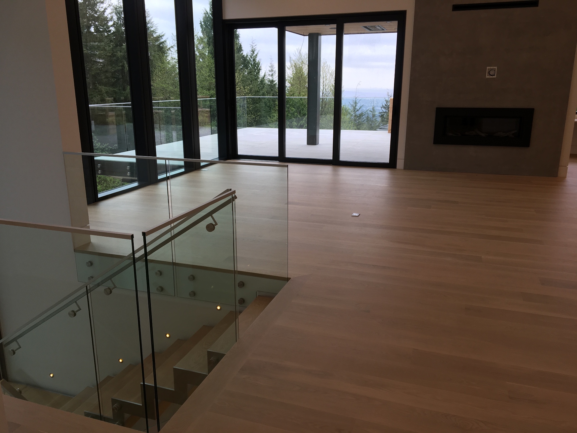 West Vancouver Home — Loba Invisible white oak flooring in living room with ocean view and fireplace