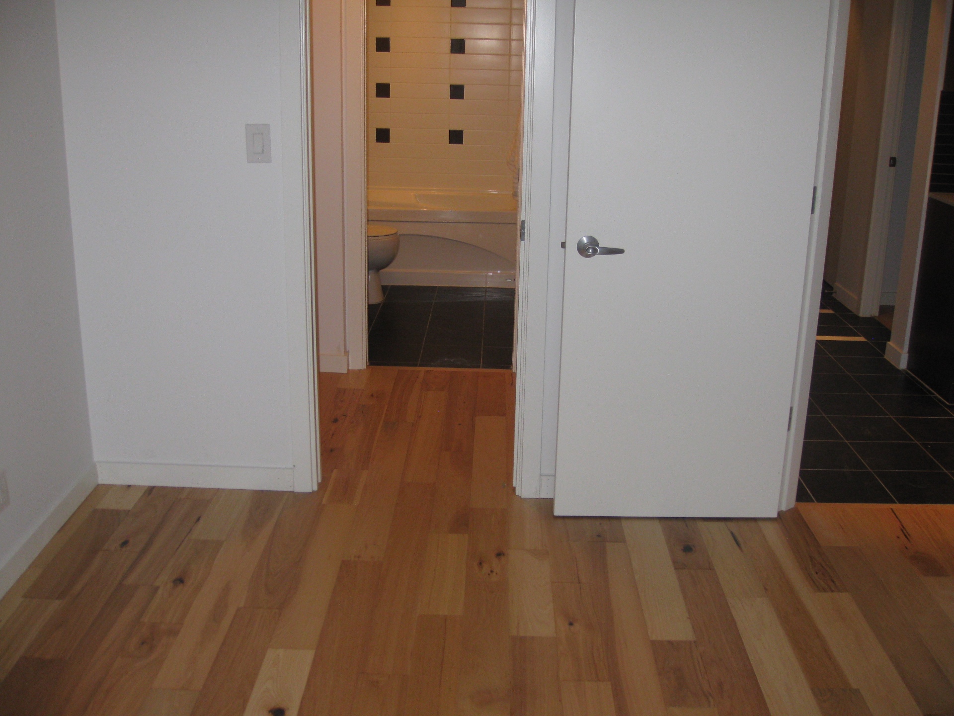 Downtown Vancouver Condo — natural hickory hardwood in hallway leading to bathroom