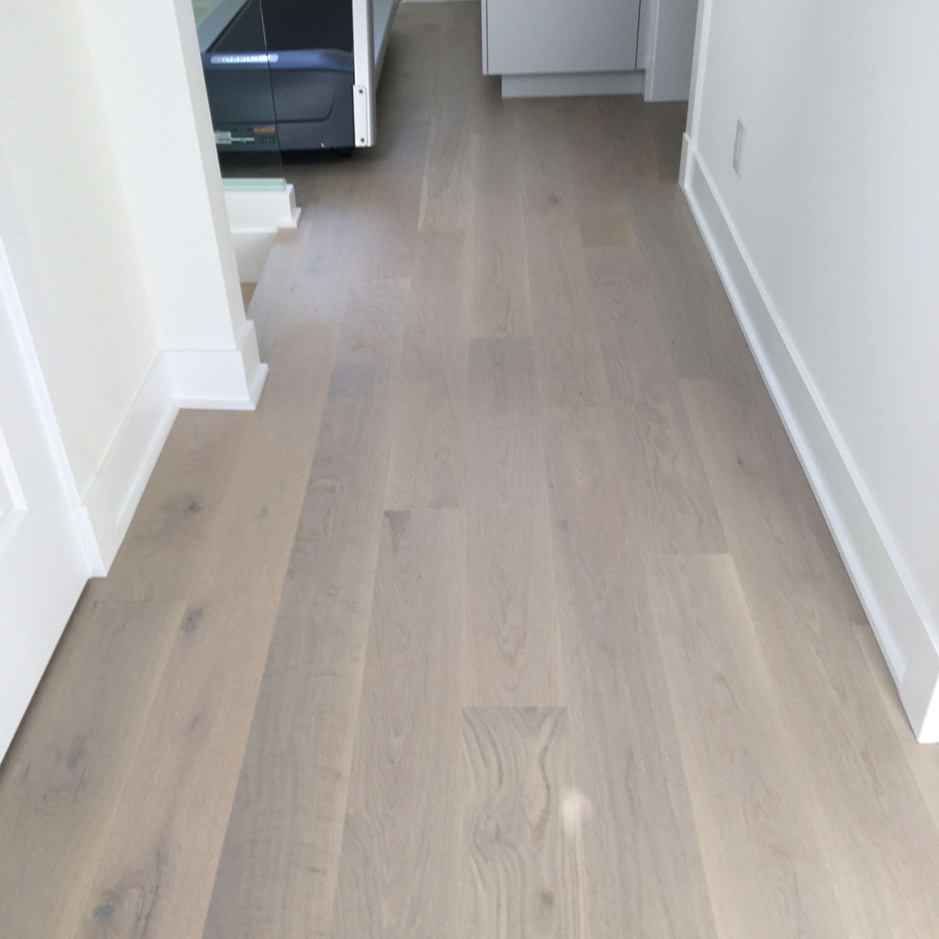 Point Grey Rd Vancouver Home — Mirage white oak hardwood running down hallway with white baseboards