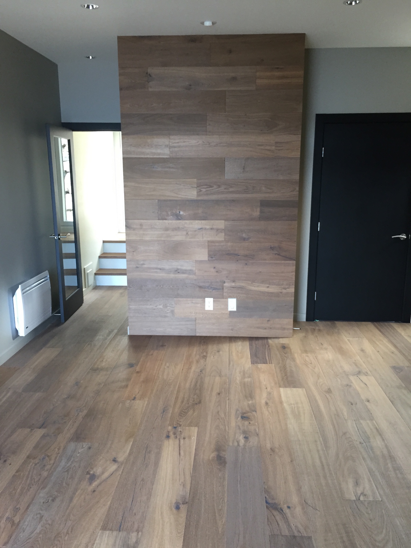Gibsons House — wide-plank oak hardwood with matching hardwood feature accent wall