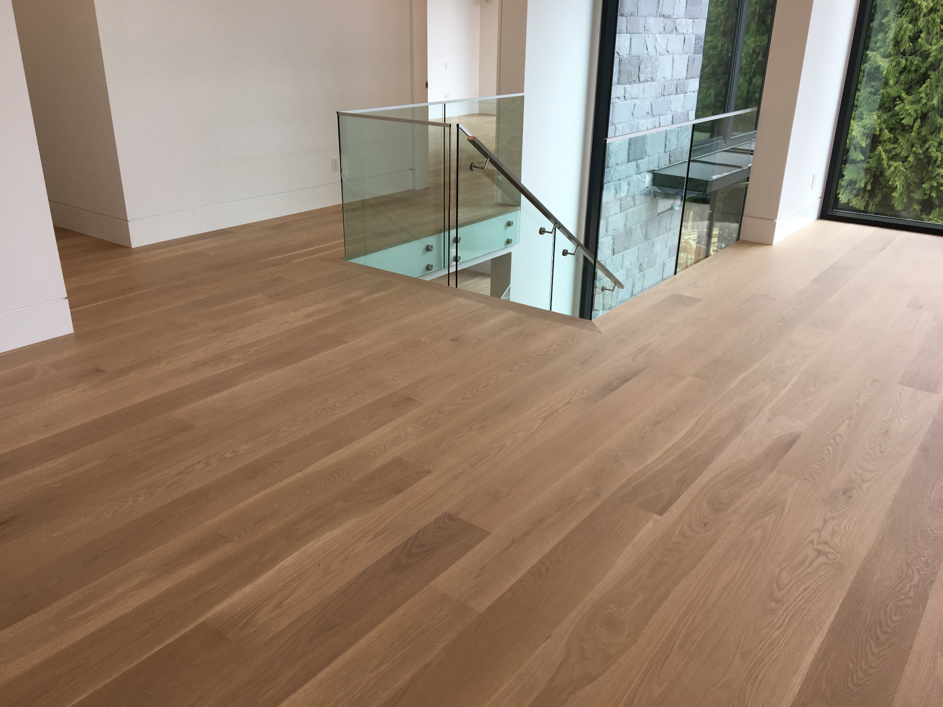 West Vancouver Home — wide-plank white oak hardwood with Loba Invisible finish on main floor with glass railings